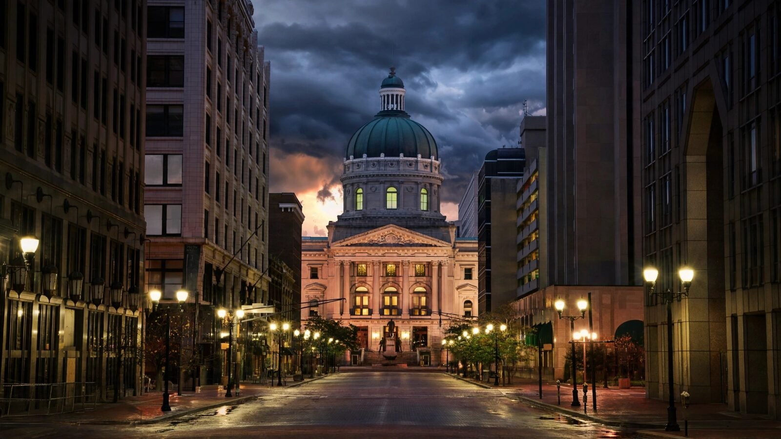 Indiana statehouse dome and capitol building at dusk in Indianapolis, seen from a lit street