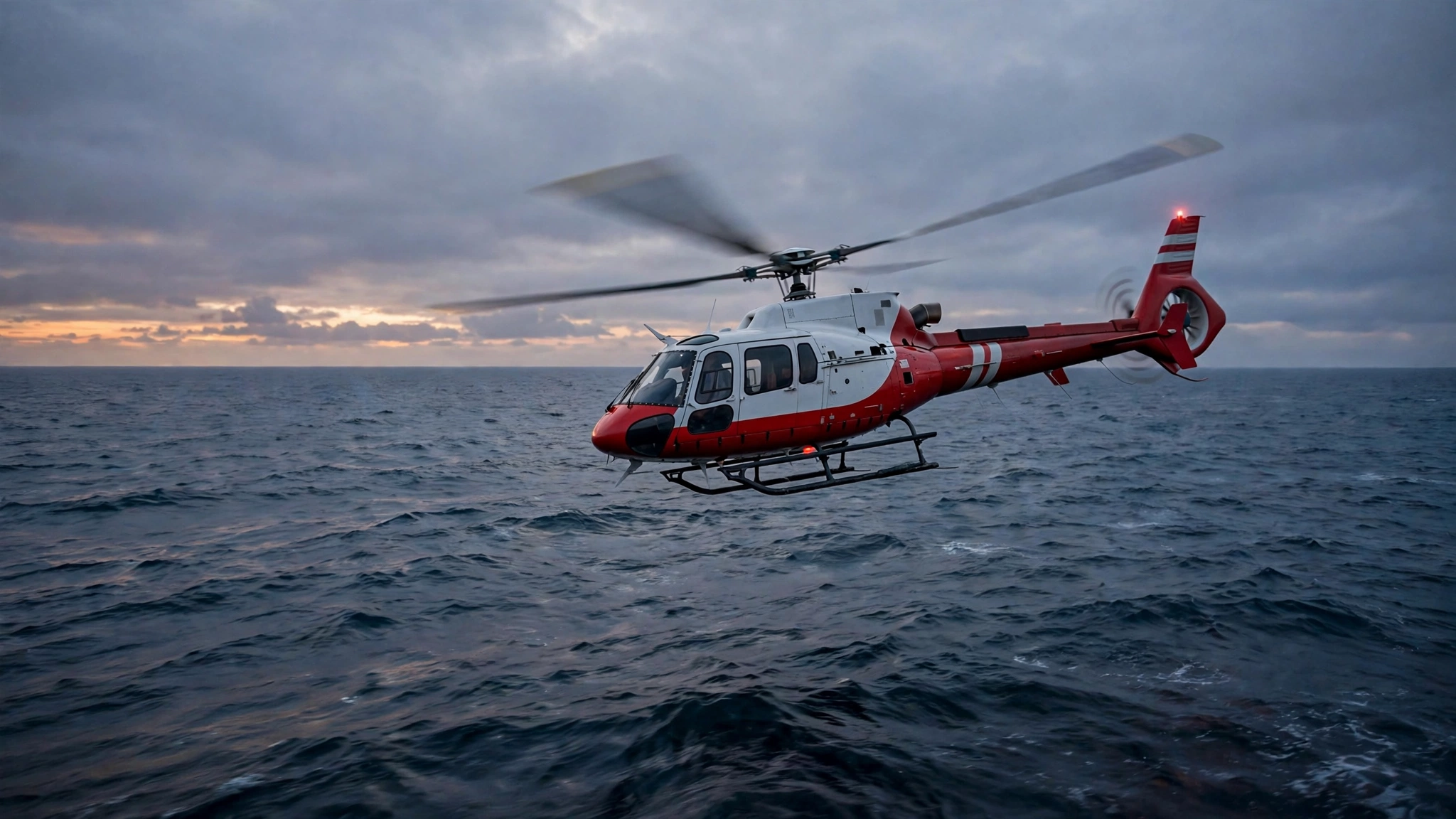 A red and white rescue helicopter flying low over the ocean at dusk