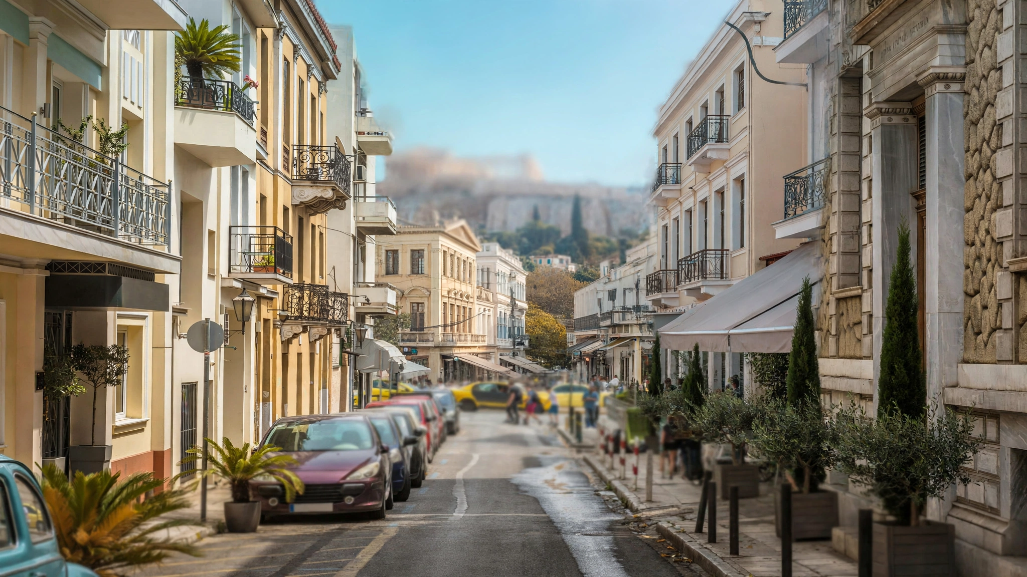A street in Athens lined with apartment buildings and parked cars, with distant pedestrians