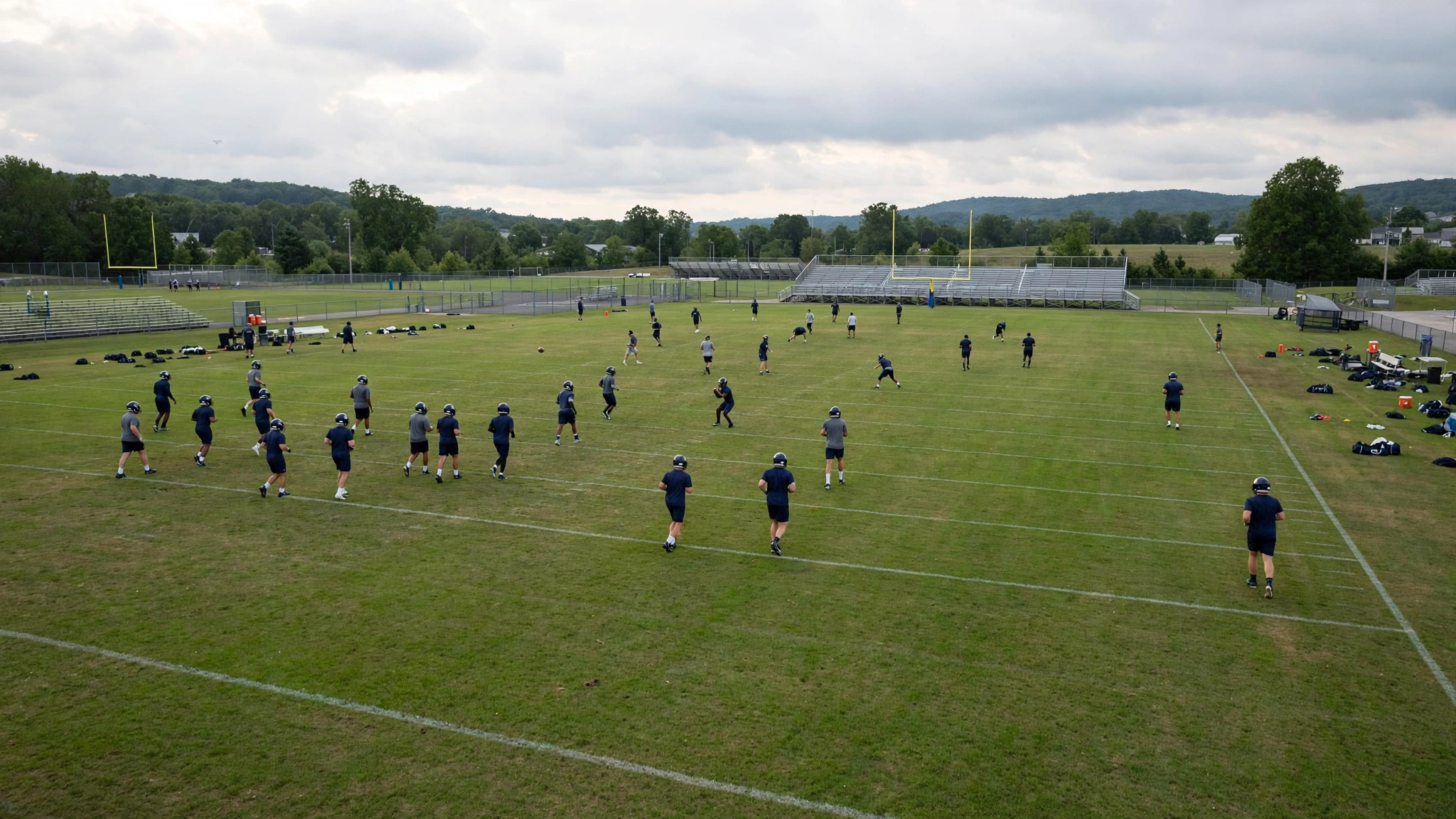 Football players in helmets warming up on a grass field