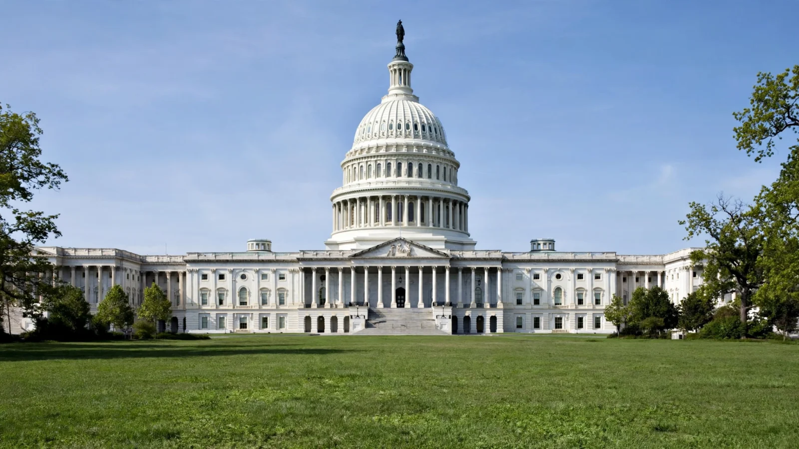 The United States Capitol building with its dome above a green lawn