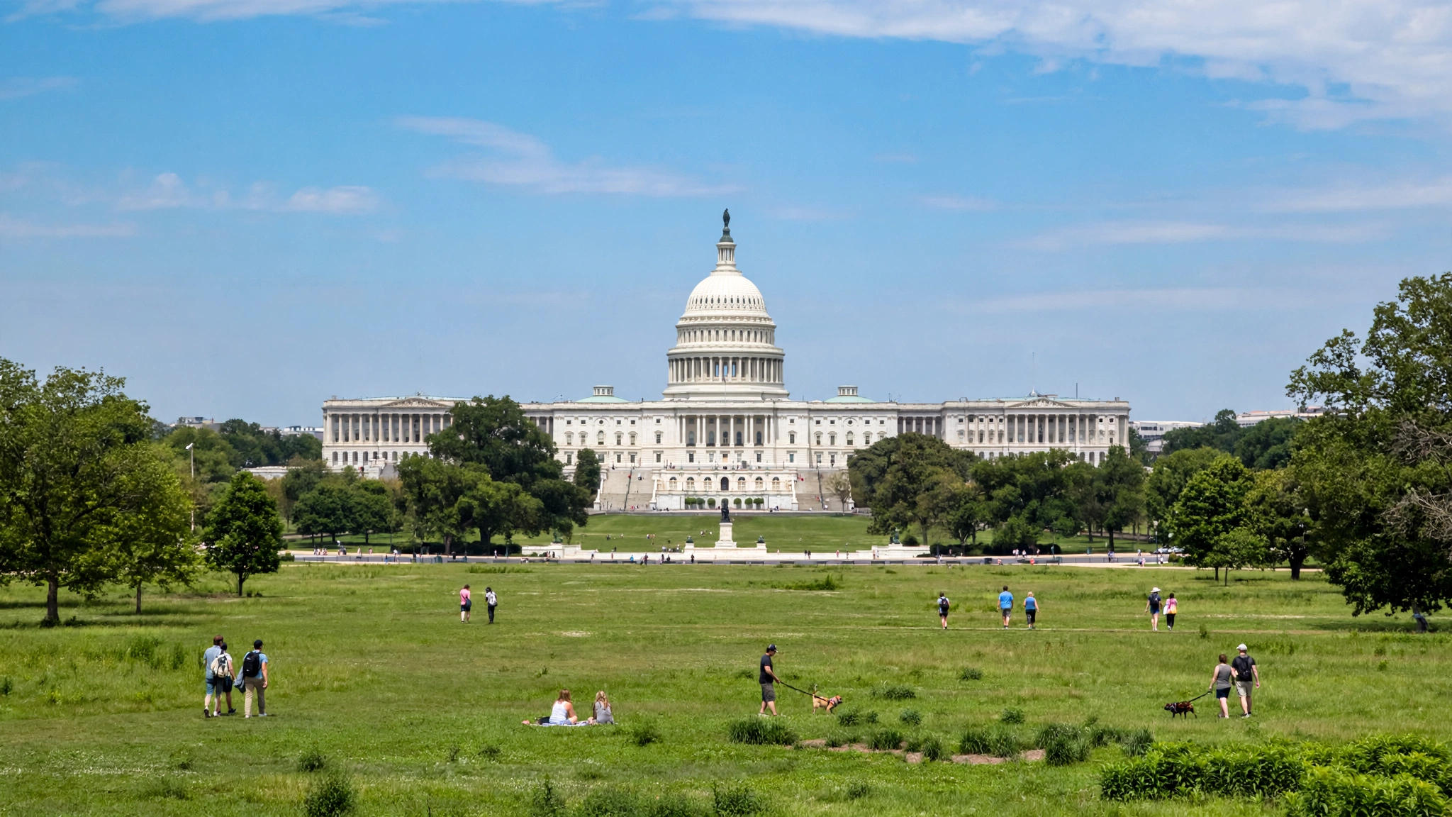 United States Capitol building seen across a grass lawn with visitors walking