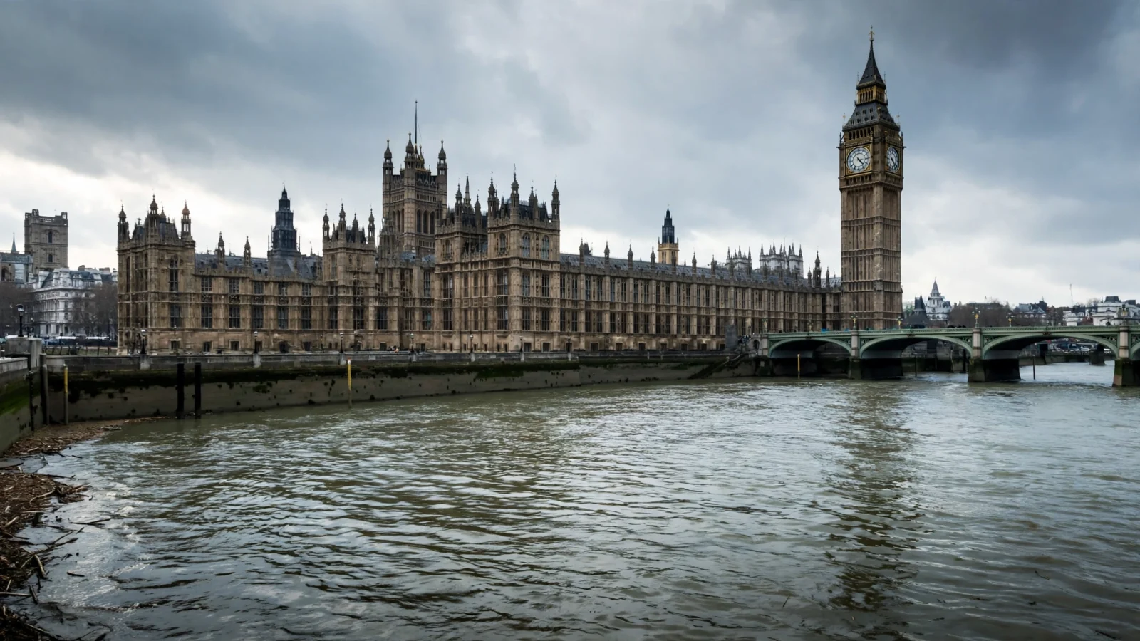 The Palace of Westminster and Big Ben beside the River Thames under a cloudy sky in London