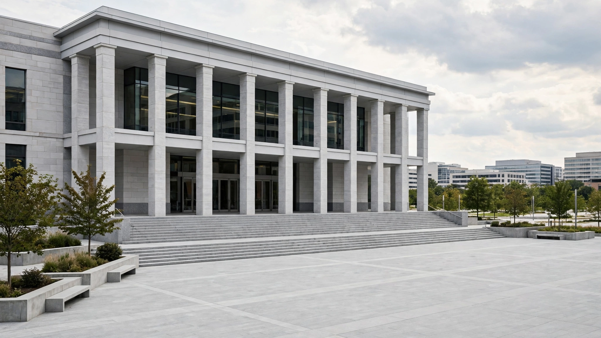 A modern courthouse building with stone columns and wide steps above an empty paved plaza