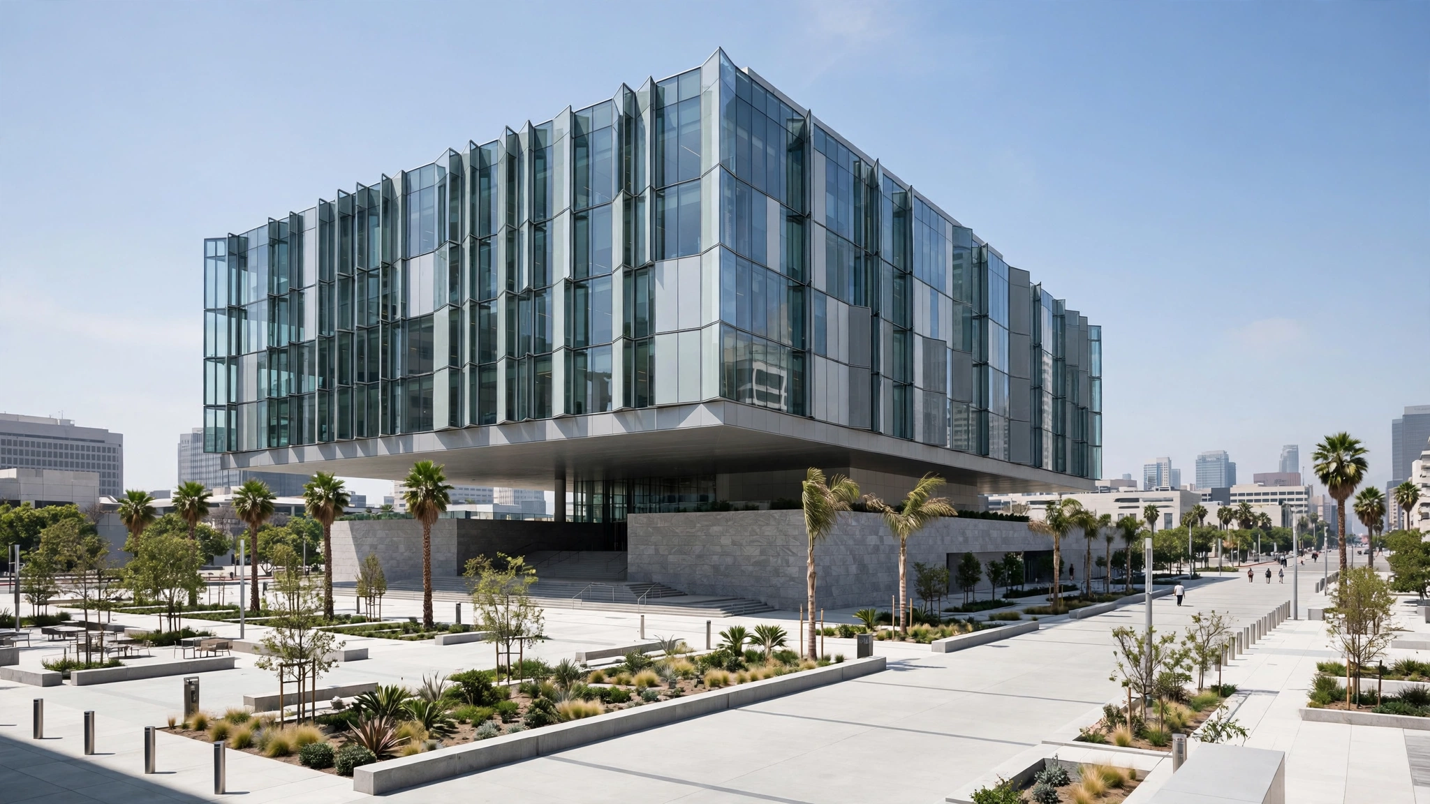 A modern glass federal courthouse building with palm trees and a wide plaza in front in daylight
