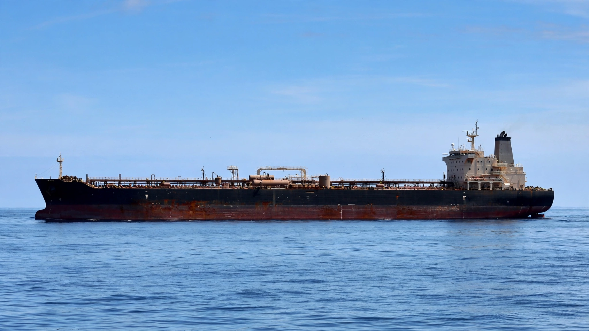 A large oil tanker sailing on calm open water under a clear sky