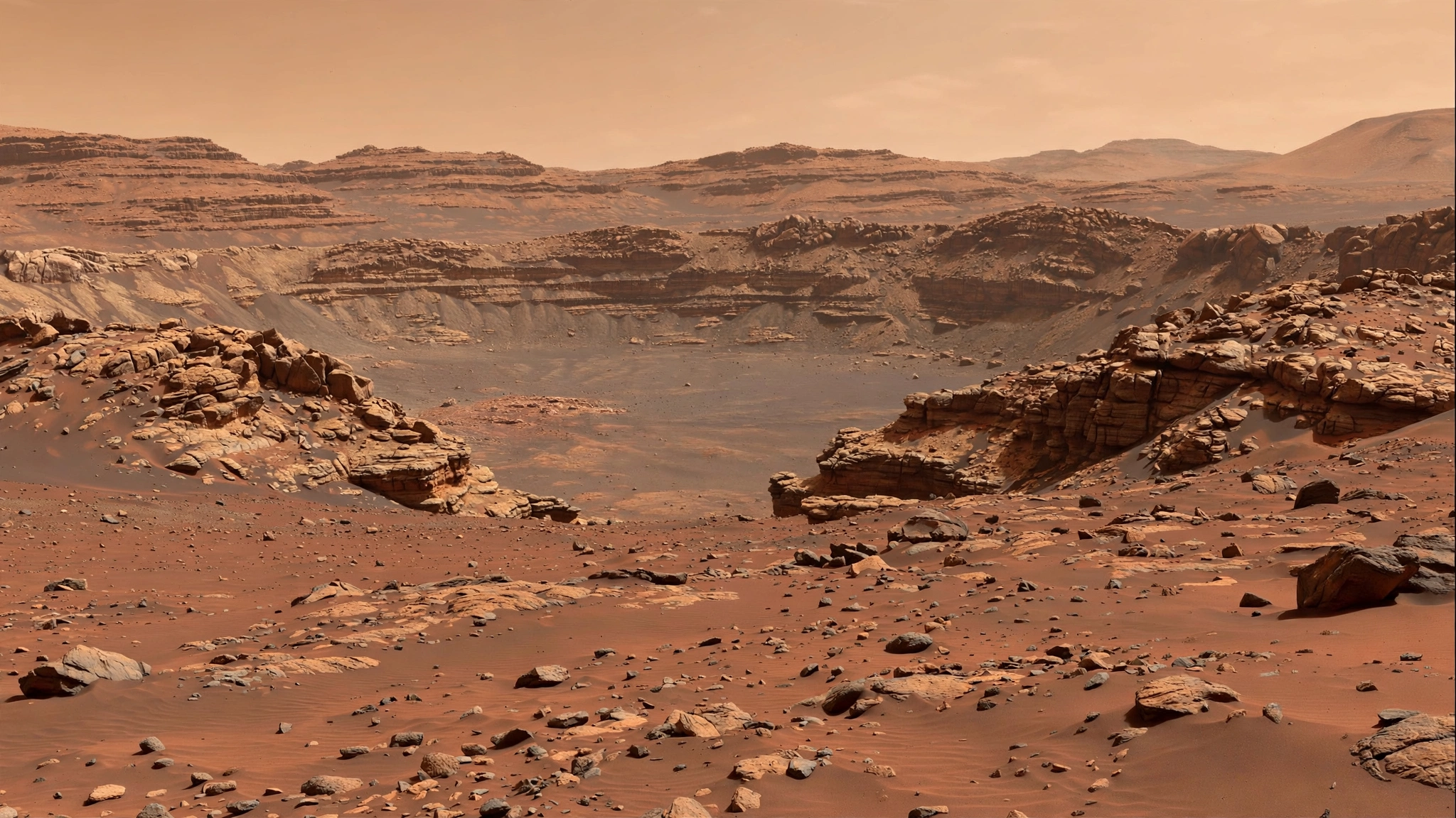 A wide view of a rocky Martian crater landscape with layered terrain under a pale orange sky.