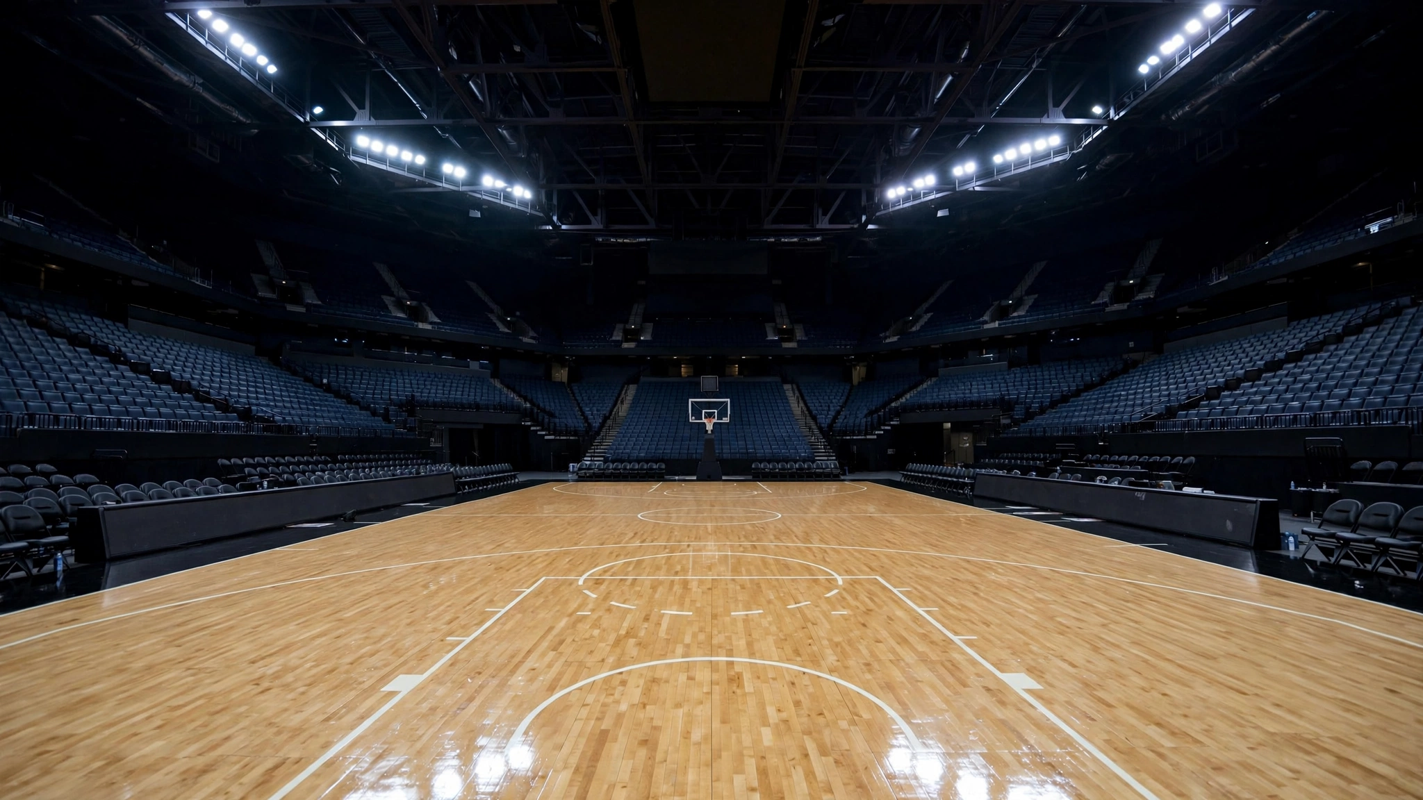 An empty professional basketball arena with a polished court under bright lights