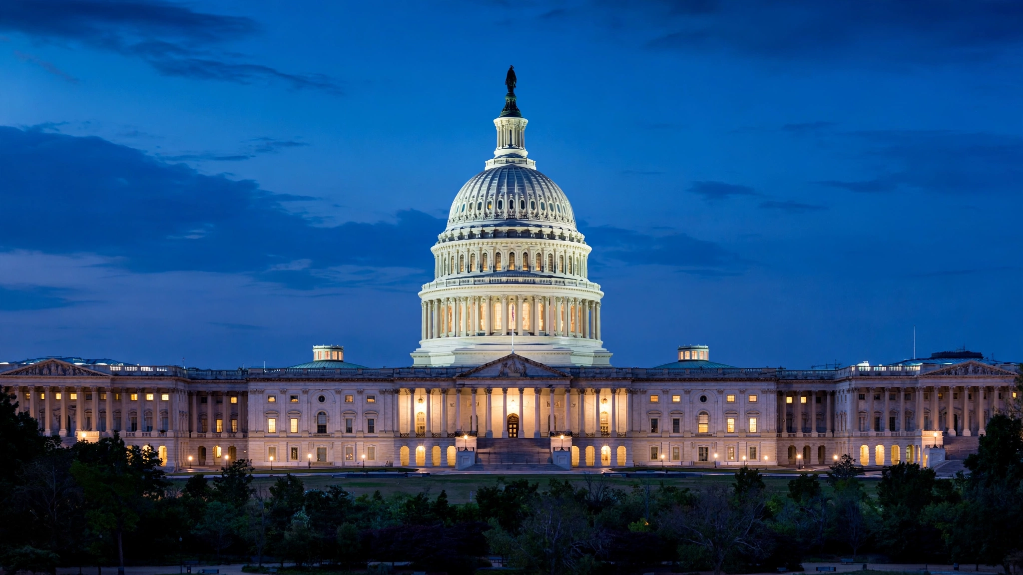 The illuminated dome of the U.S. Capitol building at dusk in Washington D.C.