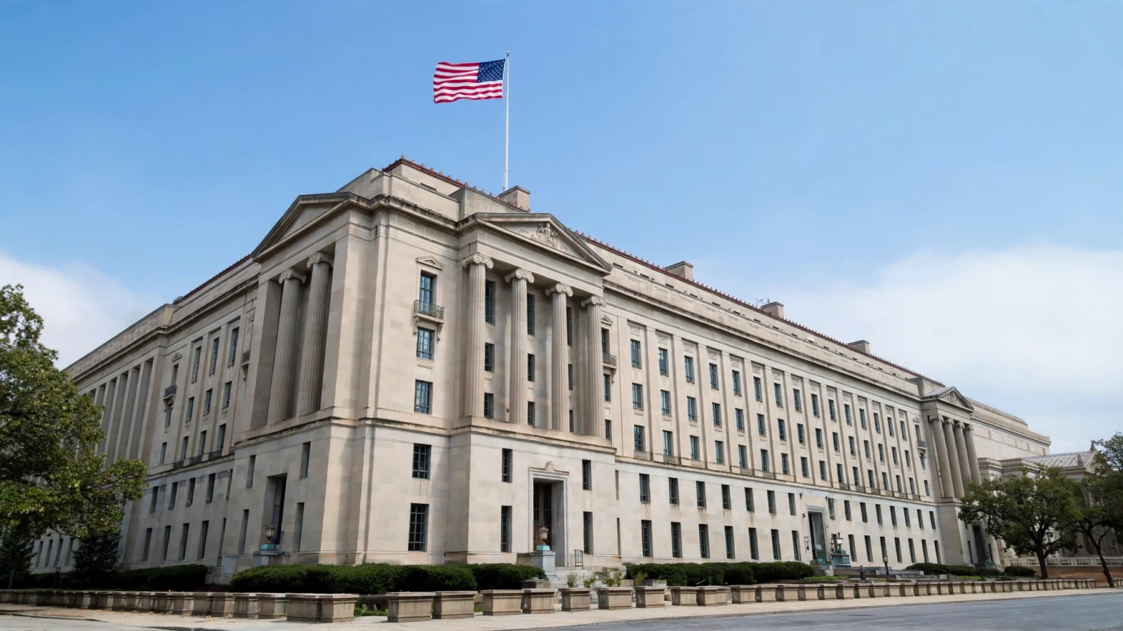 The limestone facade of the U.S. Department of Justice headquarters in Washington D.C. with an American flag flying above it