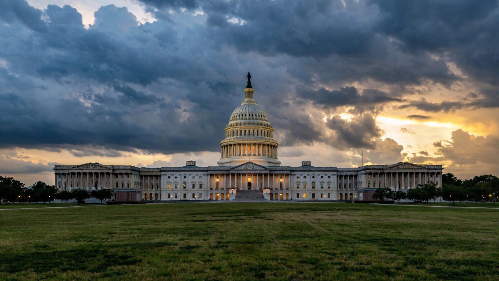 The United States Capitol building at dusk under a cloudy sky.