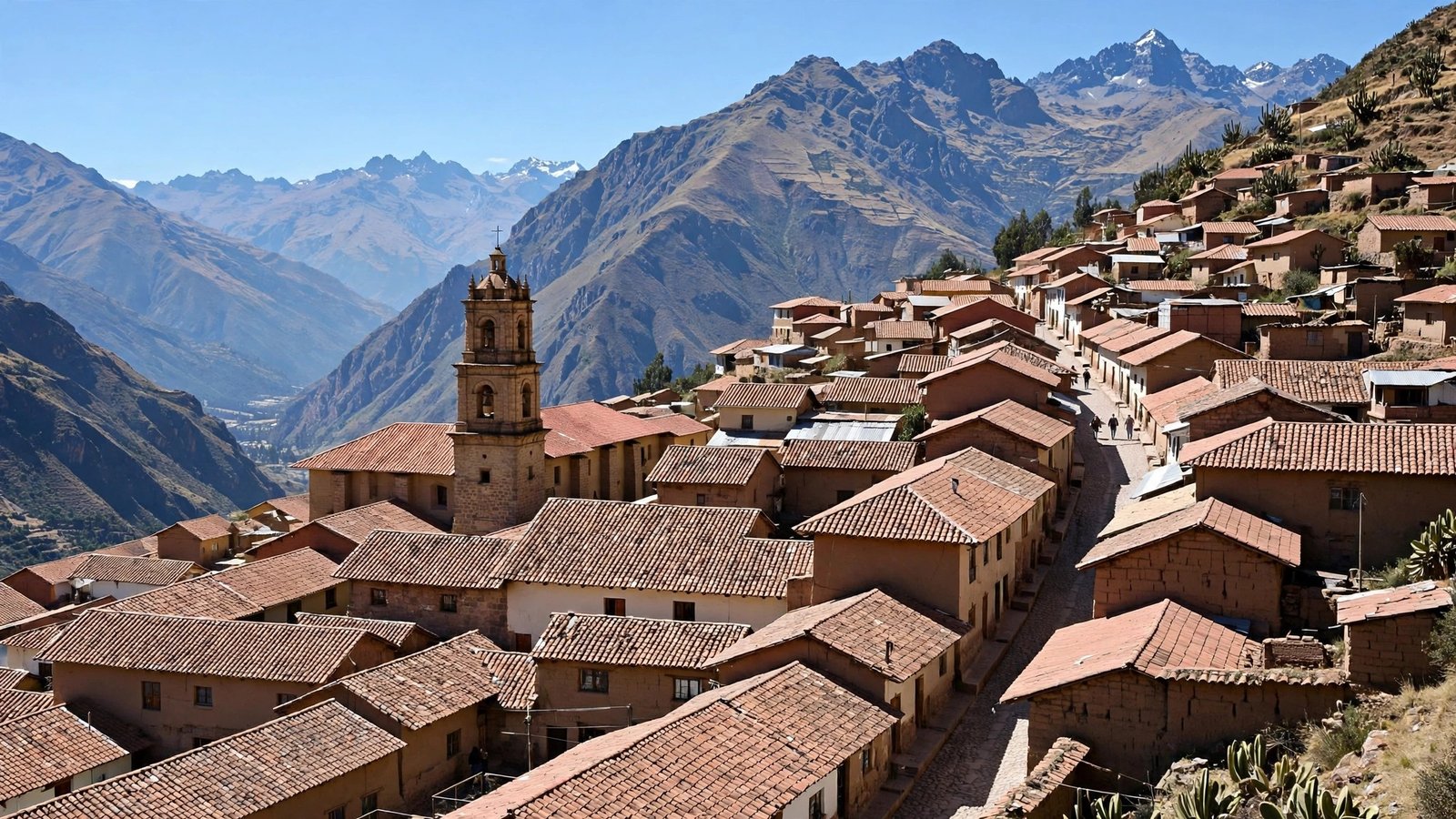 A hillside town of red-tiled roofs with a church tower, set against steep Andean mountains under a blue sky