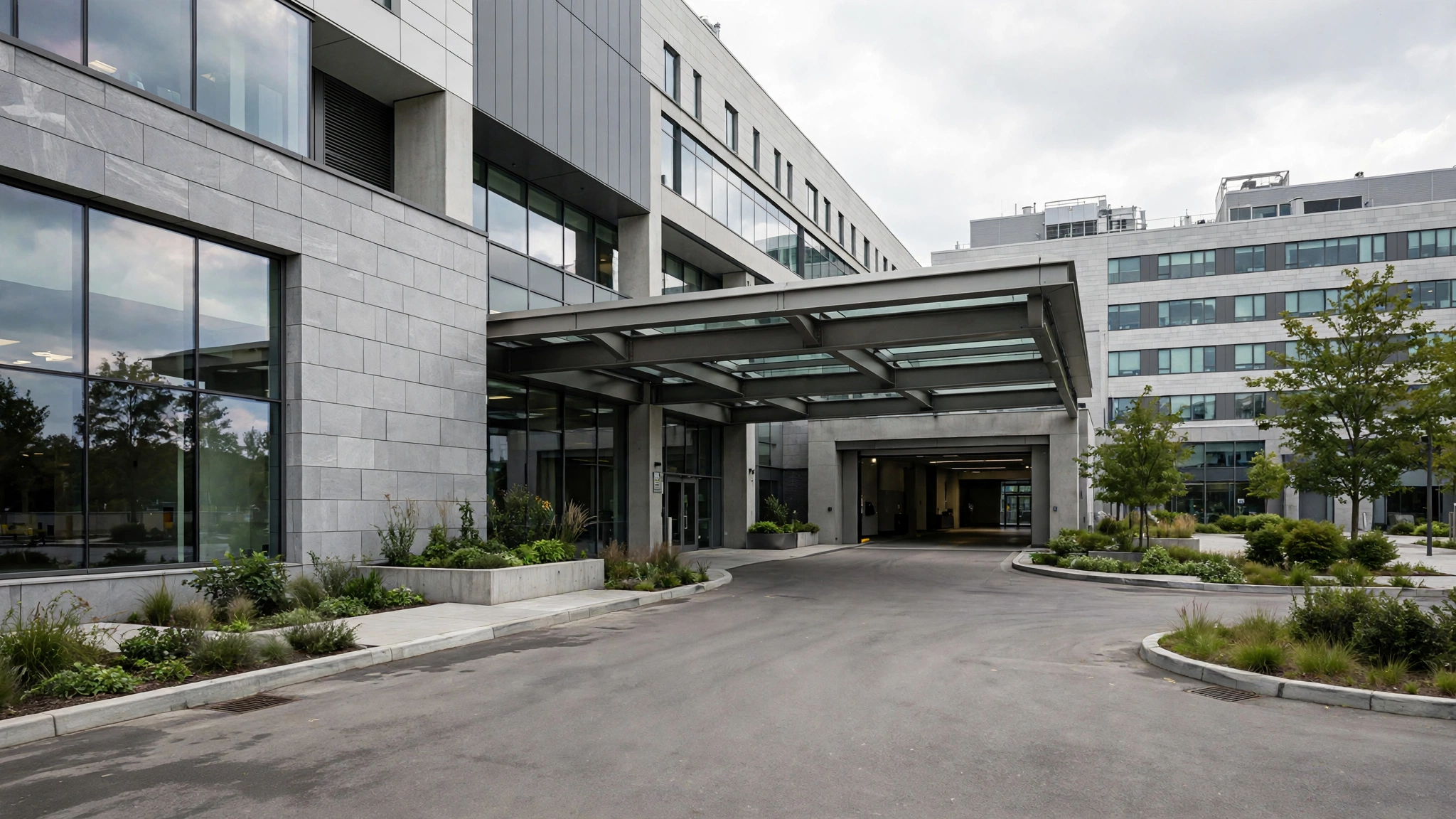 The exterior of a modern hospital building with a covered entrance driveway