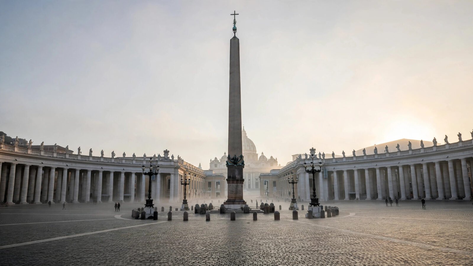 Wide view of St. Peter's Square at dawn with the obelisk and curved colonnades.