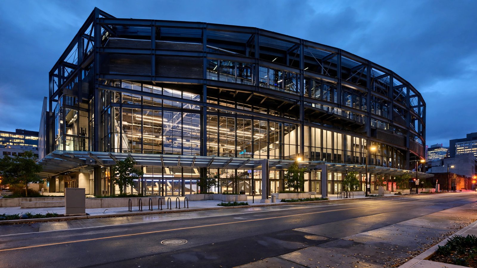 The exterior of a modern basketball arena at dusk.