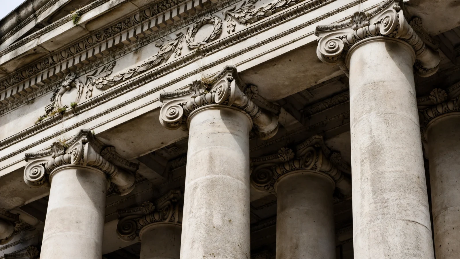 Close-up of tall stone columns and carved entablature on a neoclassical courthouse facade