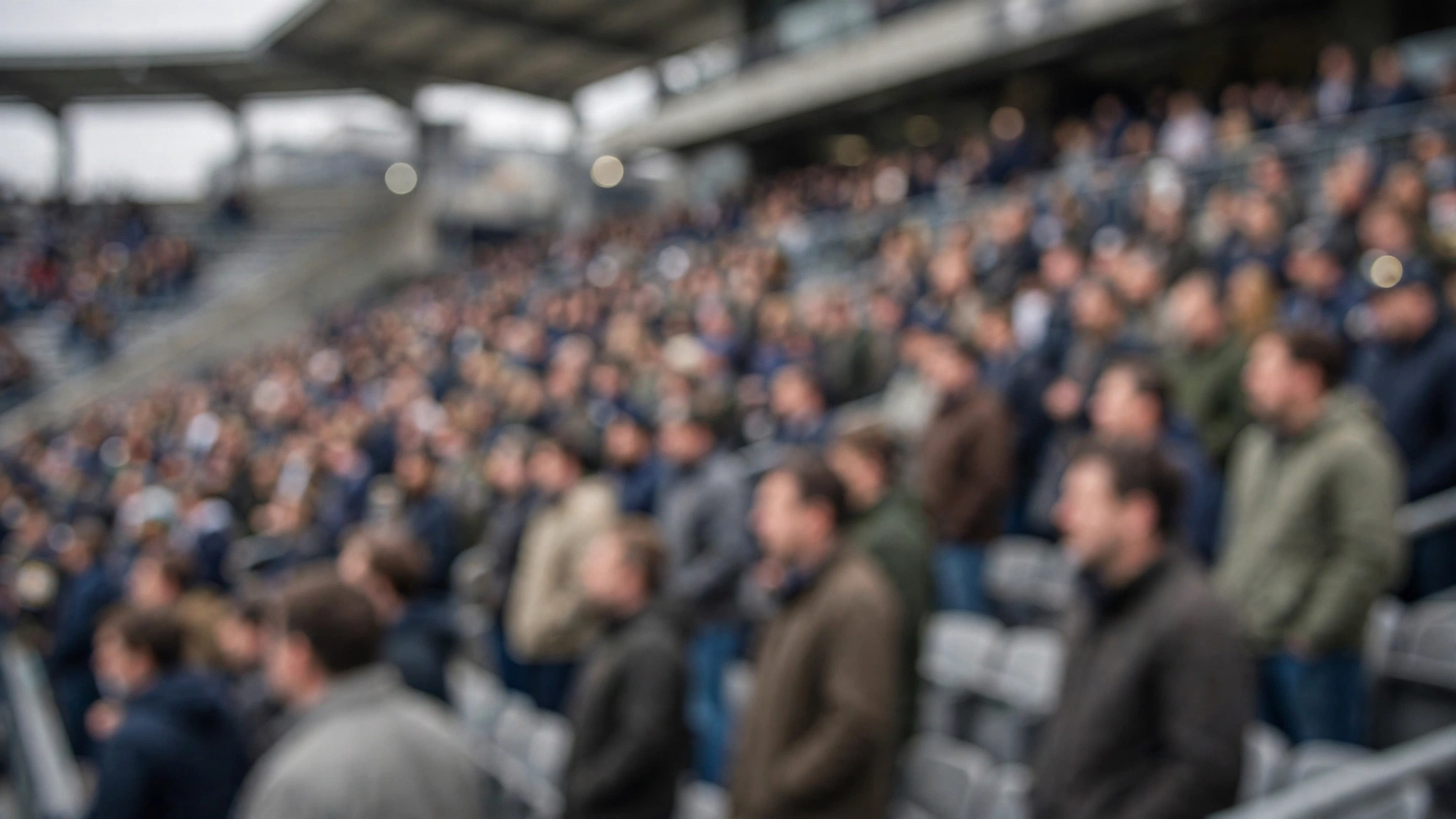 A blurred crowd of spectators standing in stadium stands on a game day.