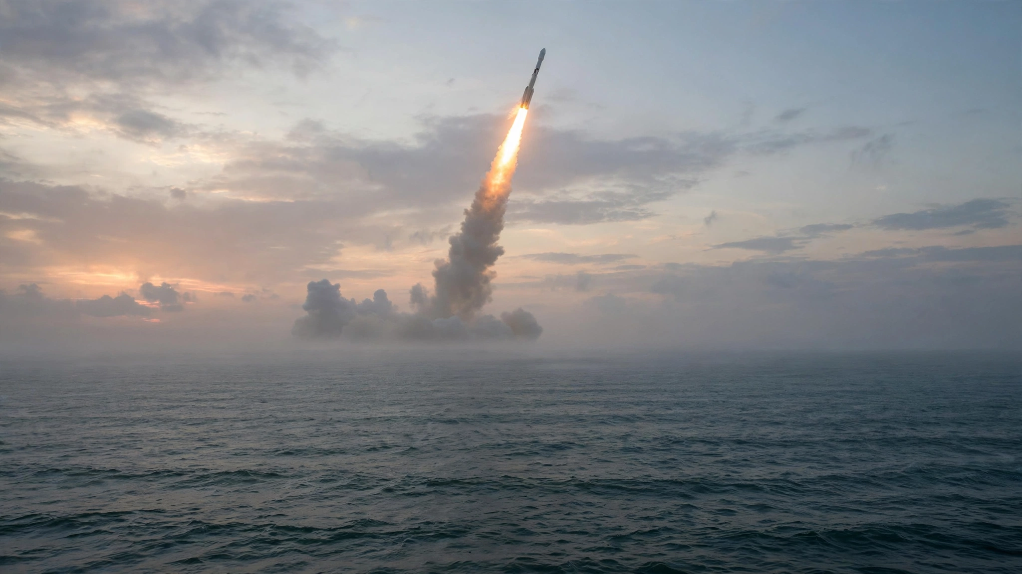 A rocket ascending over the ocean at dawn, trailing exhaust.