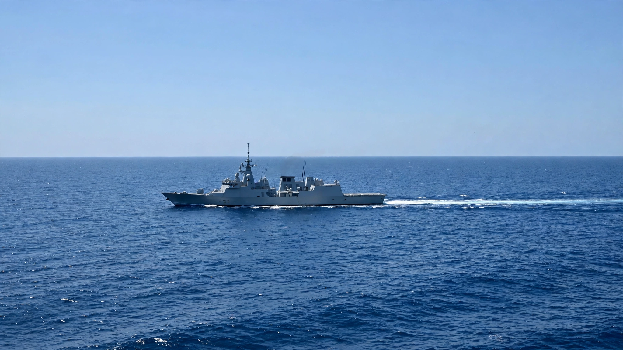 A gray naval frigate sailing on open water