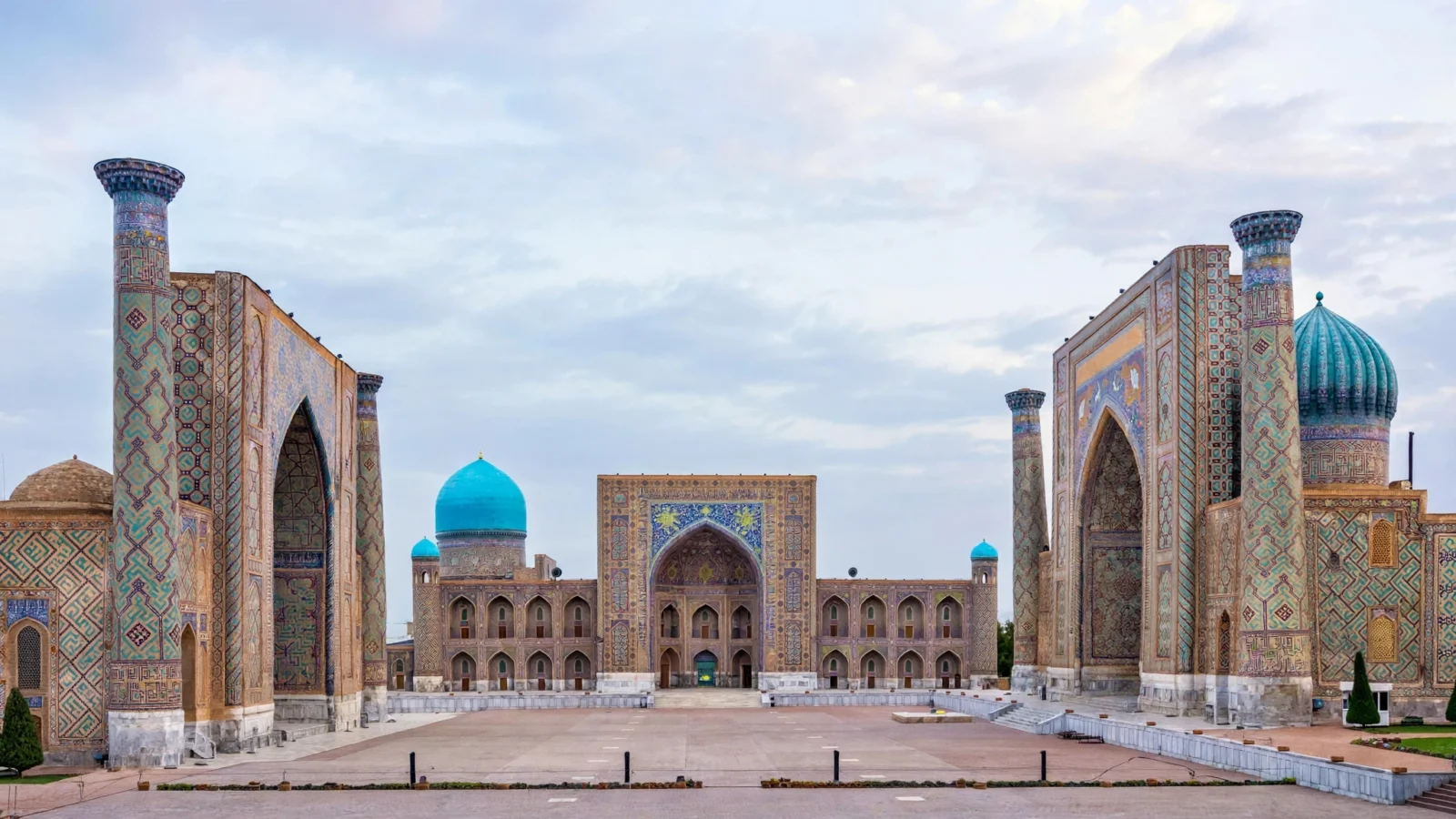 Registan Square in Samarkand, Uzbekistan, with its historic turquoise-tiled madrassas under a pale sky
