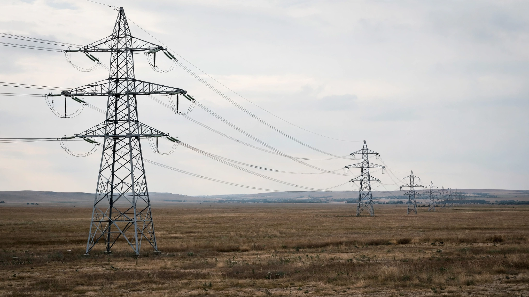 High-voltage transmission towers crossing an open field