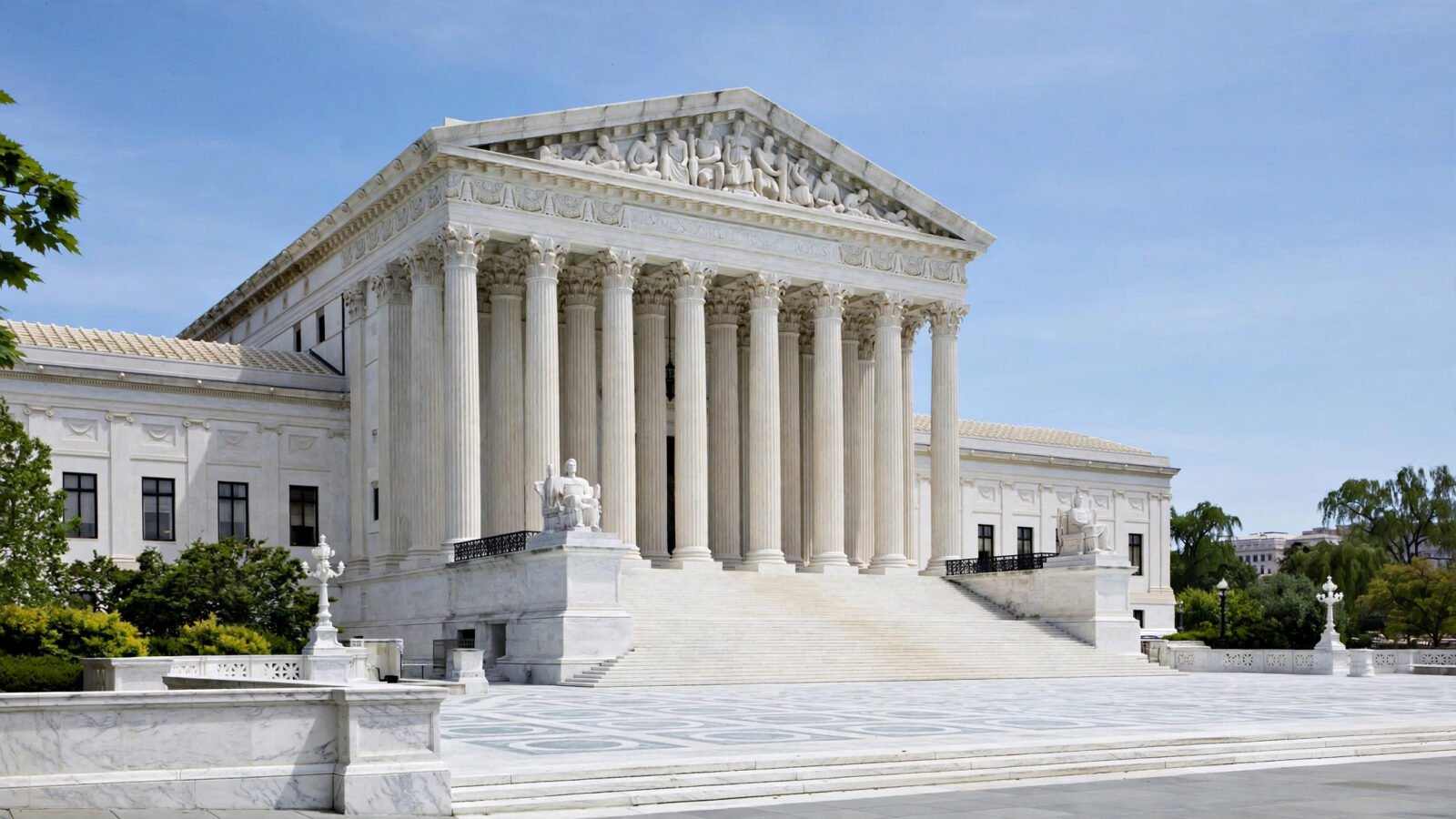 The white marble U.S. Supreme Court building with its columned facade under a blue sky.