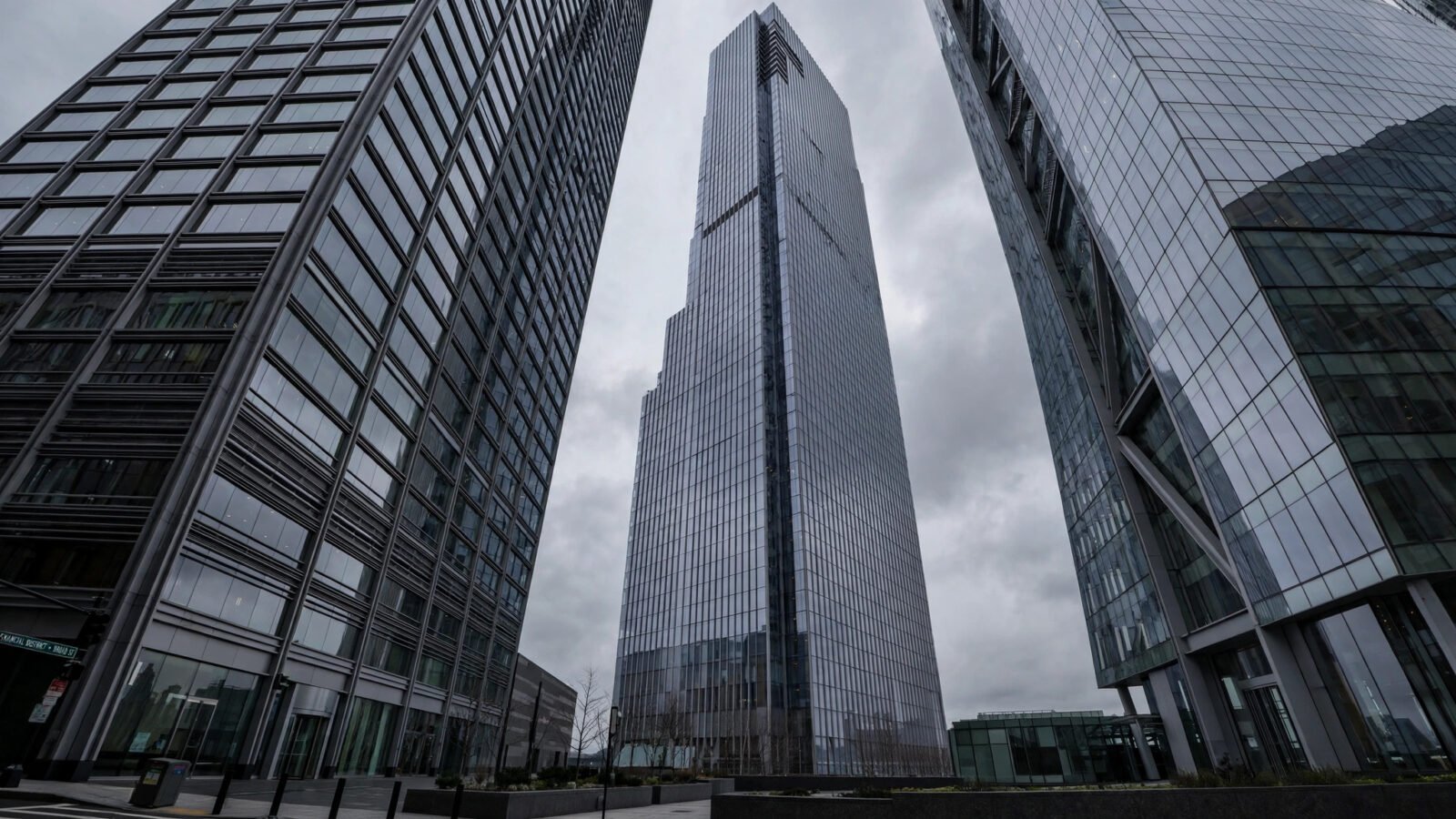 Glass skyscrapers of a financial district viewed from street level under an overcast sky