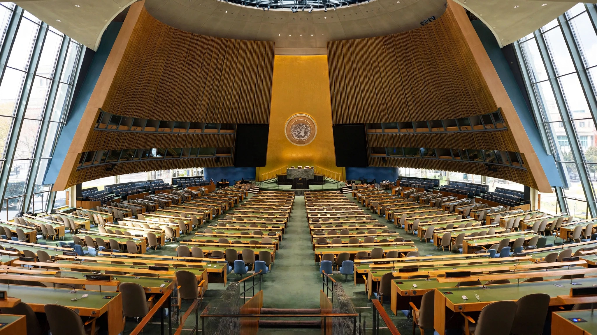 The empty United Nations General Assembly hall in New York, rows of delegate desks and the UN emblem