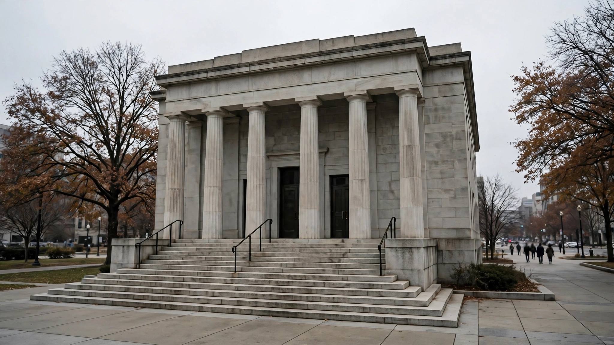 A stone courthouse building with tall columns and wide front steps on an overcast day