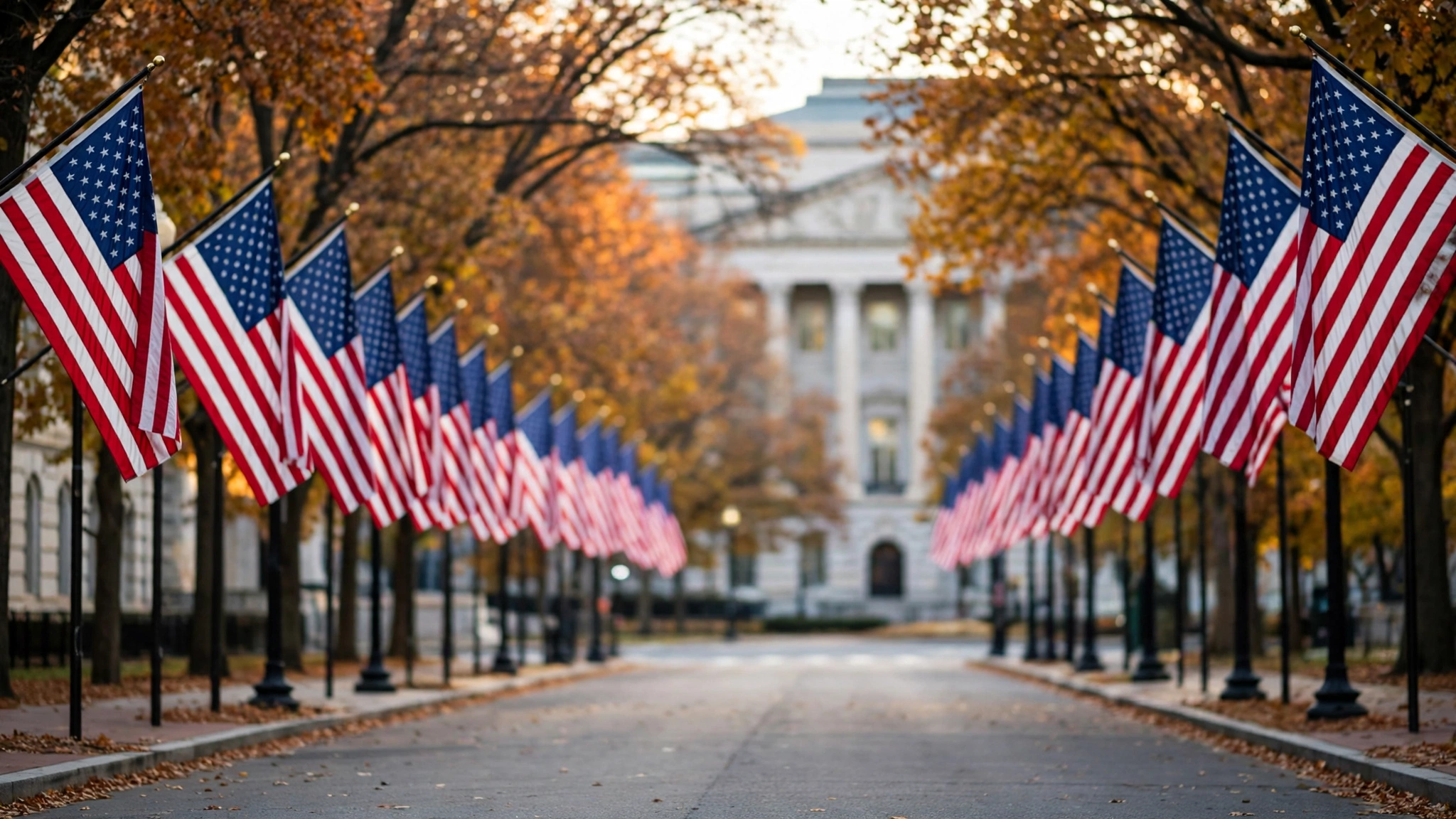 Rows of American flags lining a street in Washington, with autumn trees and a government building in the background.