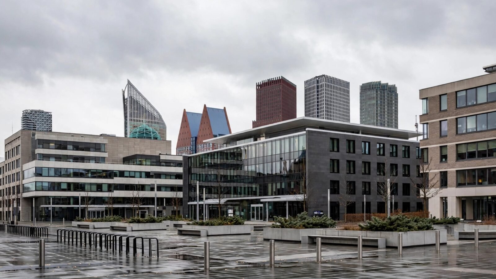 Modern government office buildings and an empty plaza in The Hague, Netherlands, under an overcast sky