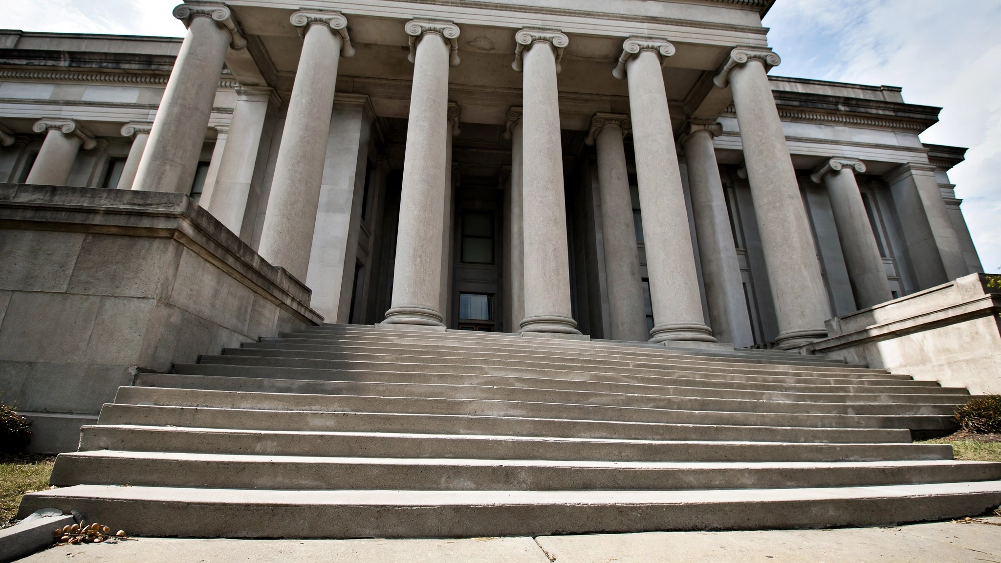 Stone steps leading up to a courthouse with tall columns.