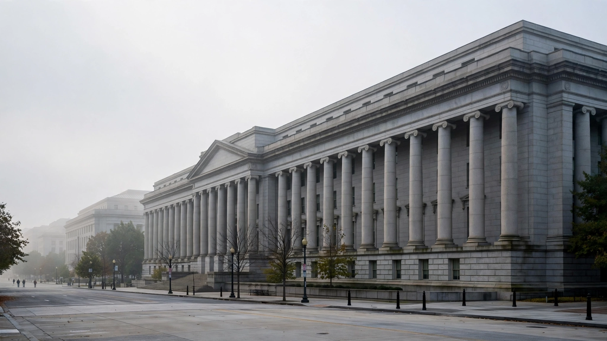 A large neoclassical stone building with tall columns along an empty street in Washington.