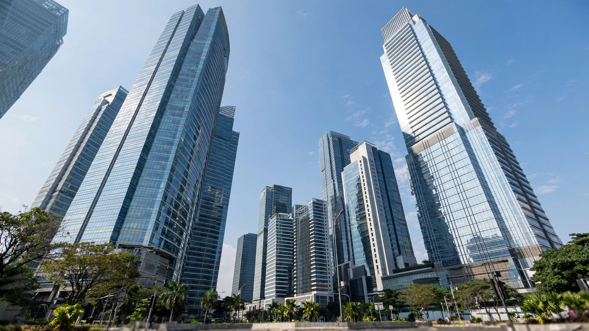 Modern glass high-rise office towers in a financial district under a blue sky