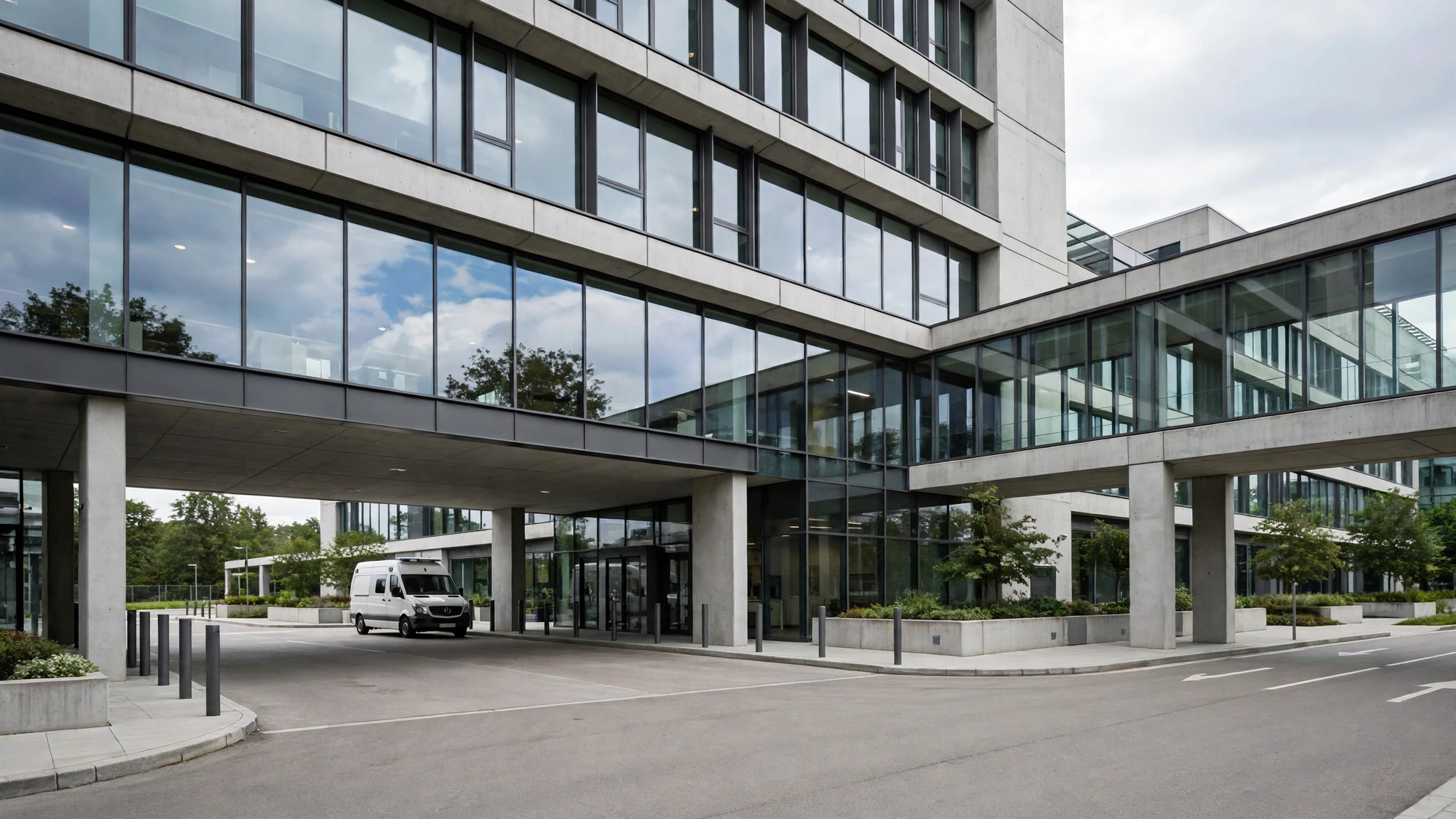 The exterior of a modern hospital building with glass and concrete in daytime.