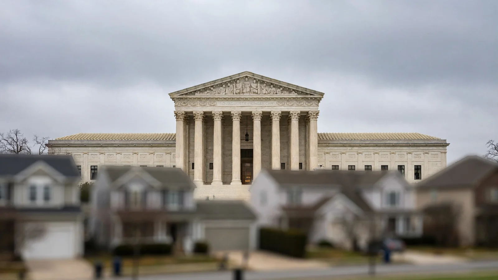 U.S. Supreme Court marble facade with columns, suburban houses blurred in the foreground