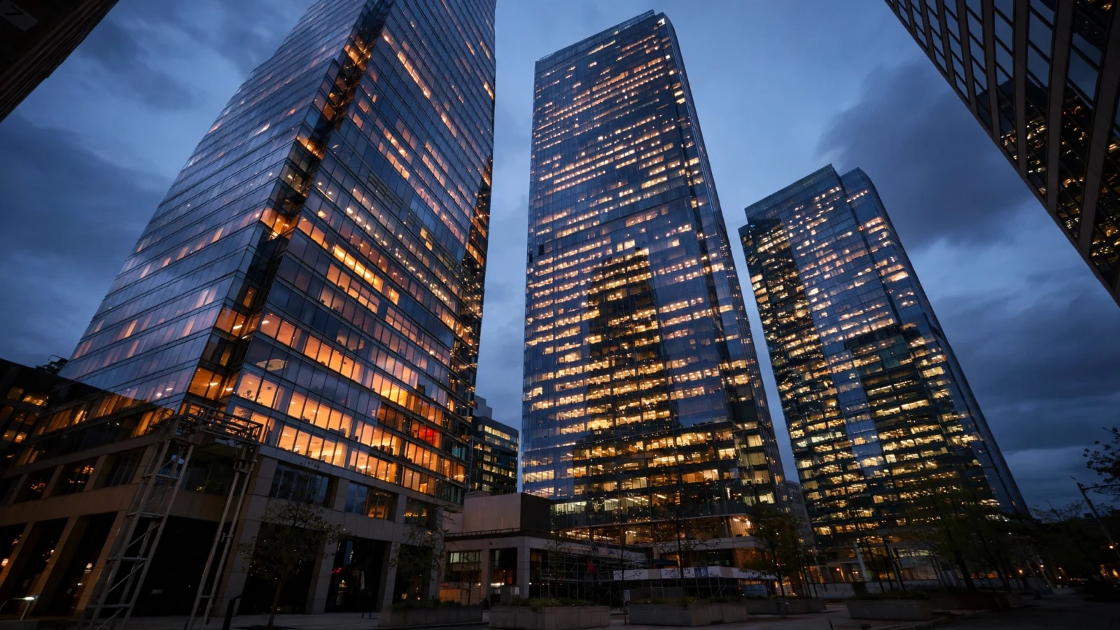Glass office towers lit up at dusk in a financial district
