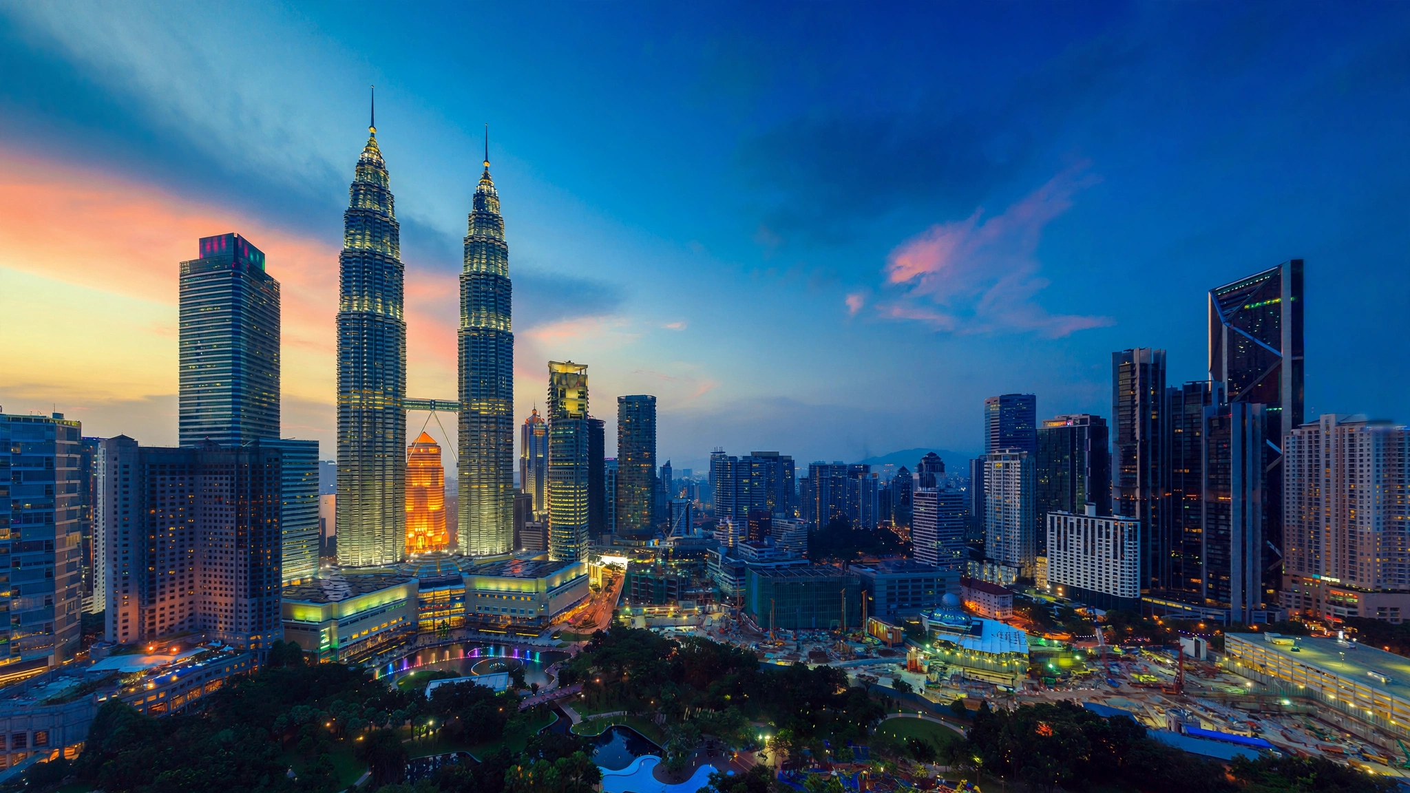 Kuala Lumpur's skyline glows at dusk, dominated by its twin-towered skyscrapers.