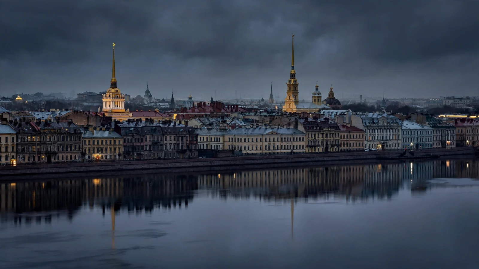 Night view of the Saint Petersburg skyline with illuminated spires reflected in the river
