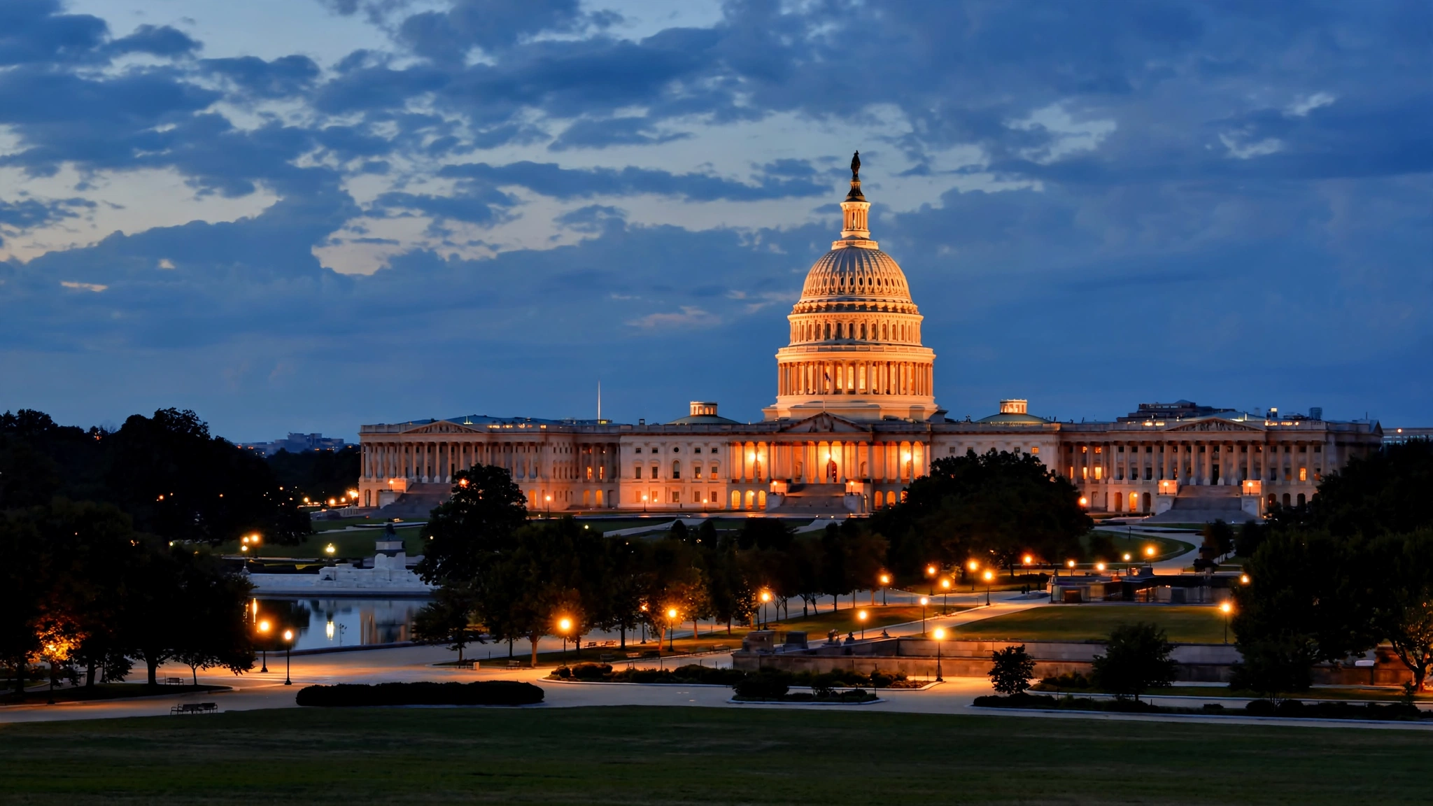 The U.S. Capitol dome illuminated at dusk, viewed from across the National Mall