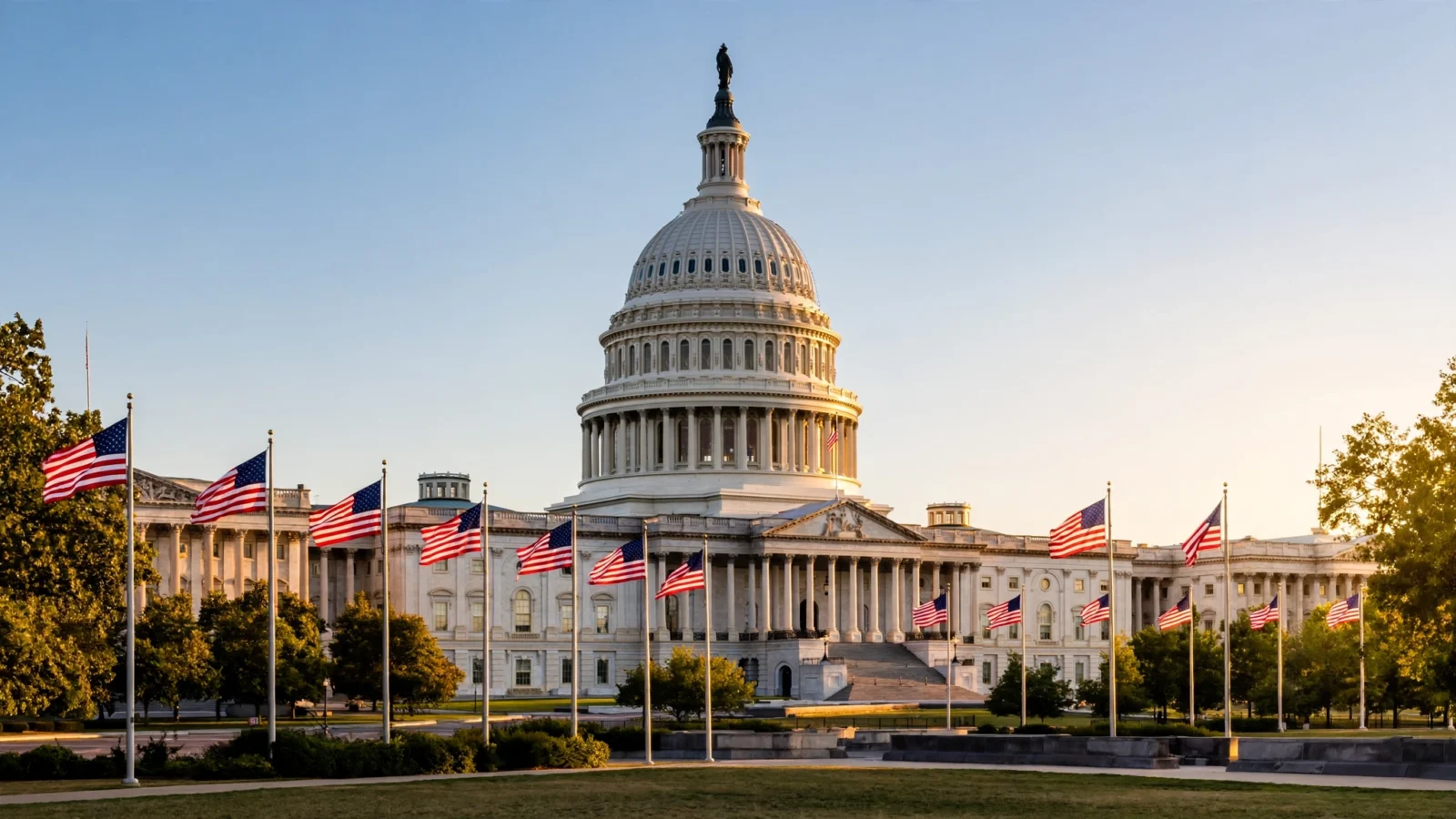 The United States Capitol dome in Washington, D.C., with American flags flying in front at golden hour