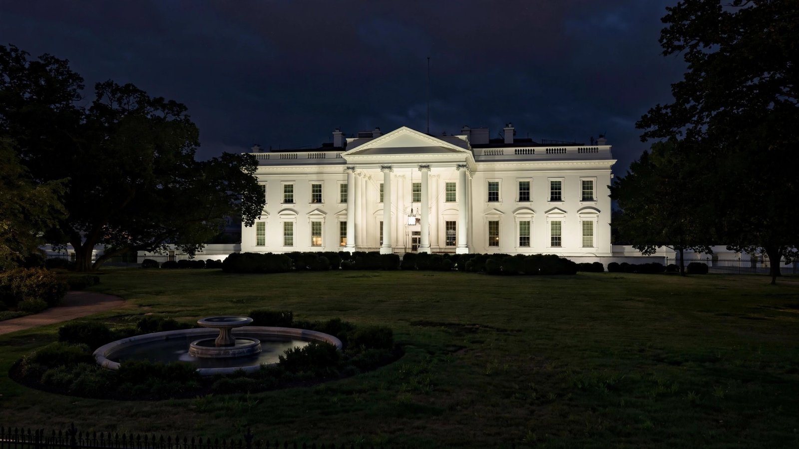 The White House lit up at night, seen from the north lawn