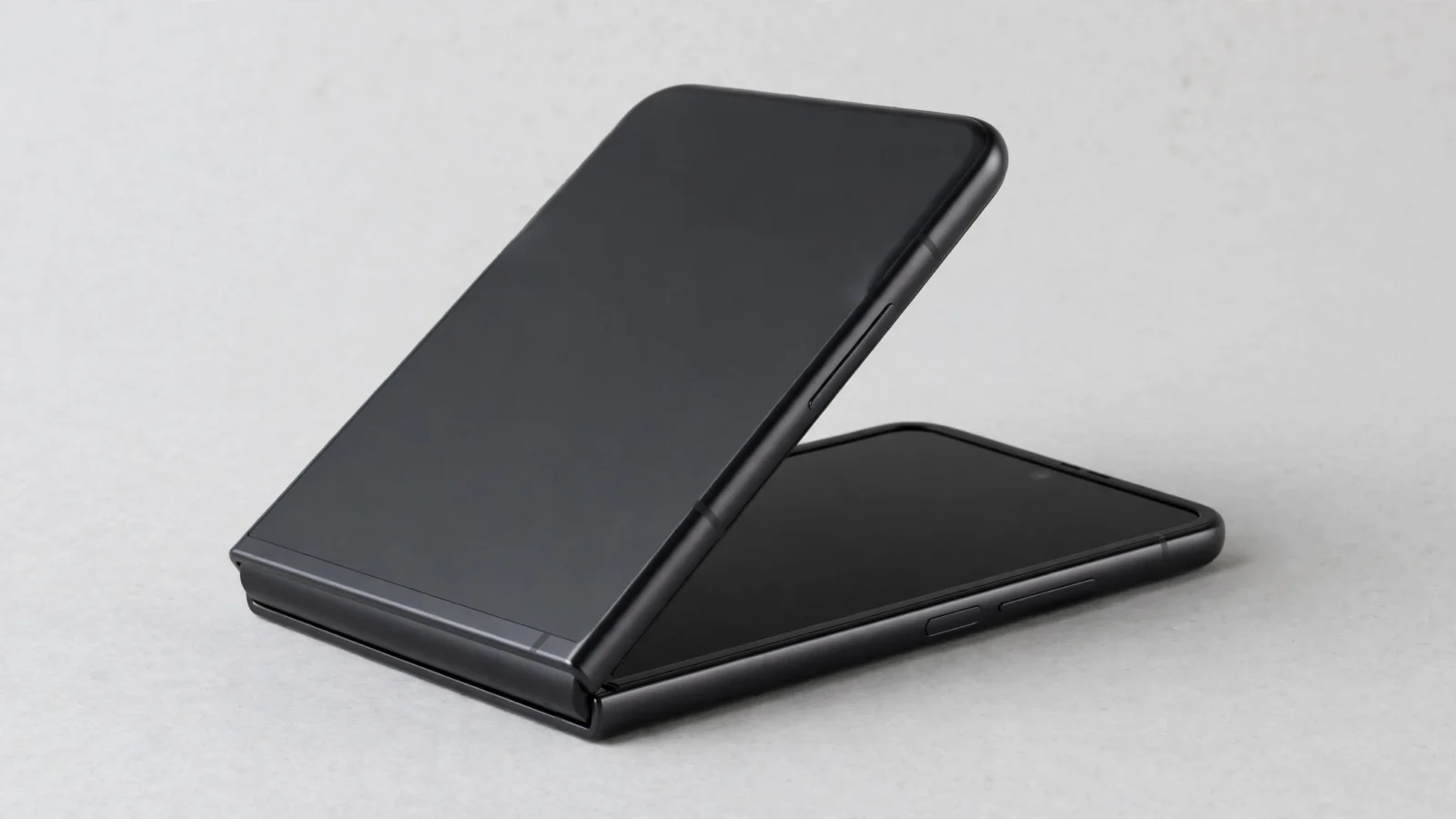 A black foldable smartphone half open on a gray surface. The iPhone Duo, Apple's first foldable phone, sold out within minutes of pre-orders opening Friday.