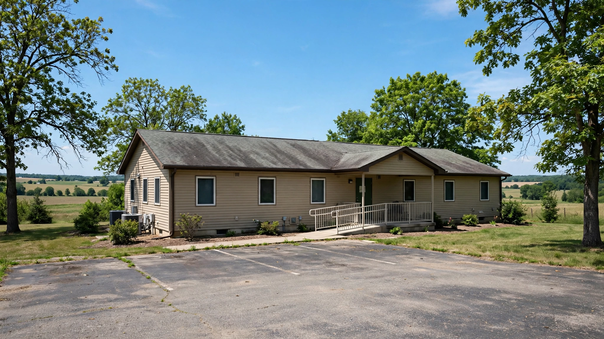 A small single-story nursing home building with a parking lot in a rural setting